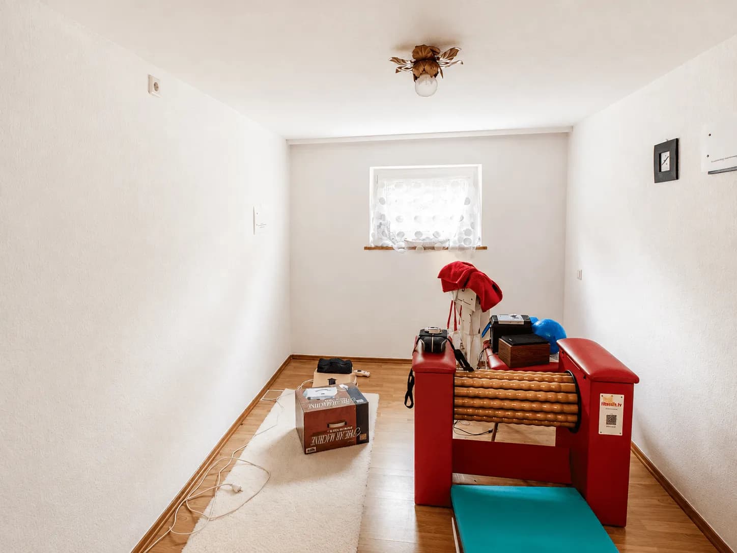 Heller Hobby- oder Fitnessraum im Untergeschoss mit Laminatboden, weißen Wänden, Tageslichtfenster und Rollenmassagegerät in Burgkunstadt.