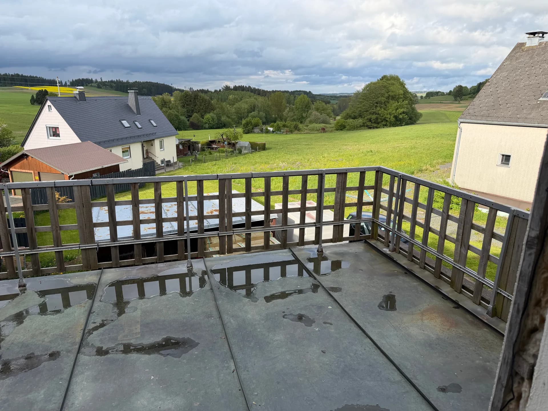 Großzügige Dachterrasse/Balkon mit Holzgeländer und weitem Panoramablick über die malerische Landschaft und umliegende Natur.