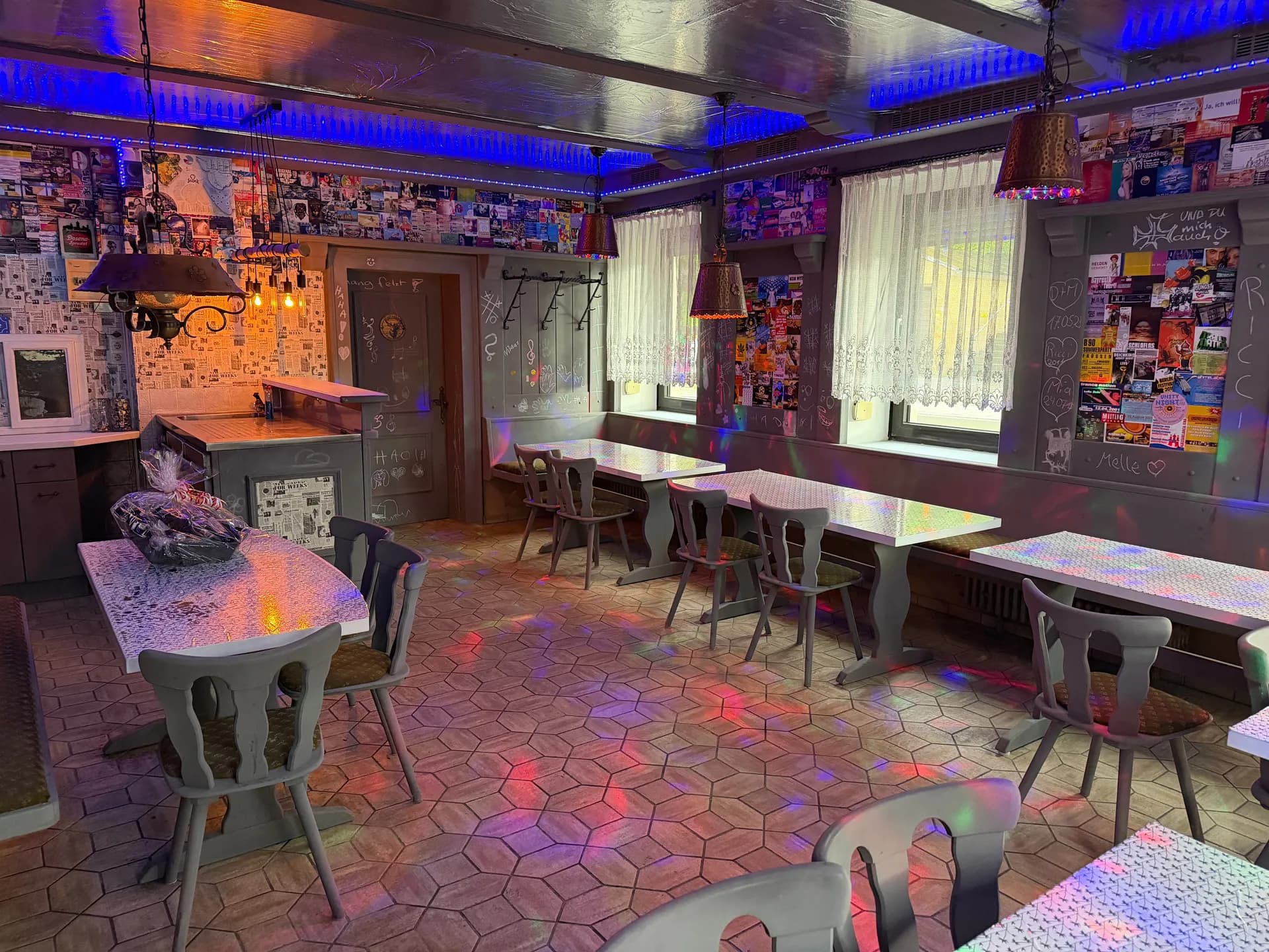 Urig ausgestatteter Party- und Aufenthaltsraum mit Barbereich, mehreren Sitzgruppen, dekorativen Hängeleuchten und stimmungsvoller LED-Beleuchtung.
