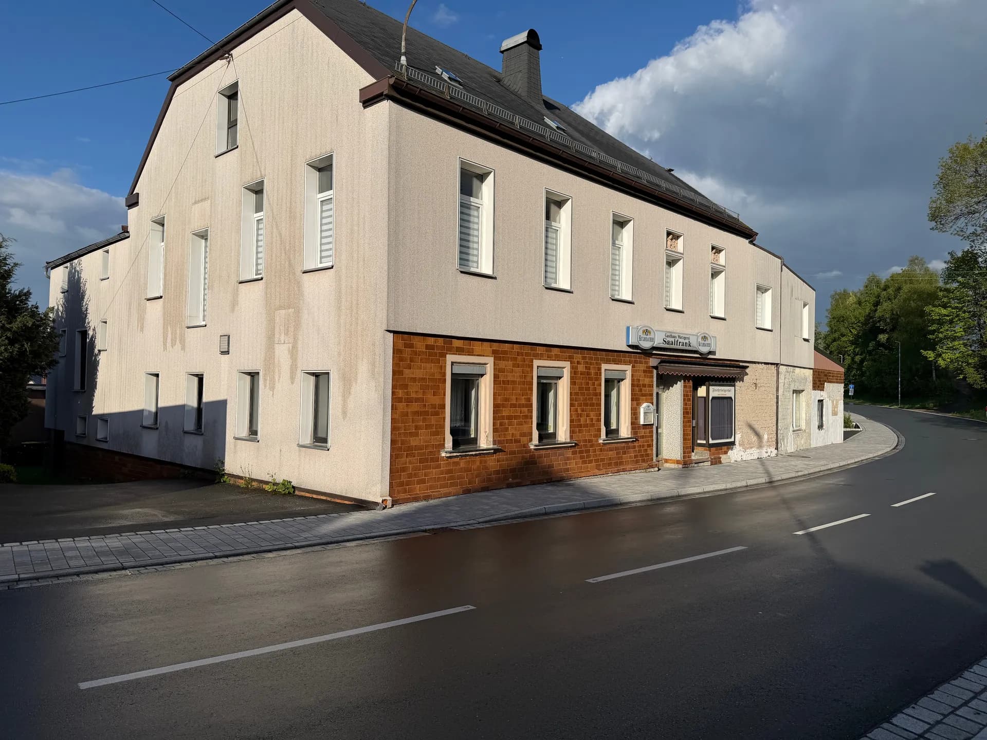 Markante Straßenansicht des Gebäudes: massiver Baukörper mit Klinkerriemchen im Erdgeschoss, separatem Eingangsbereich und idealem Potenzial für gewerbliche oder gemischte Nutzung.