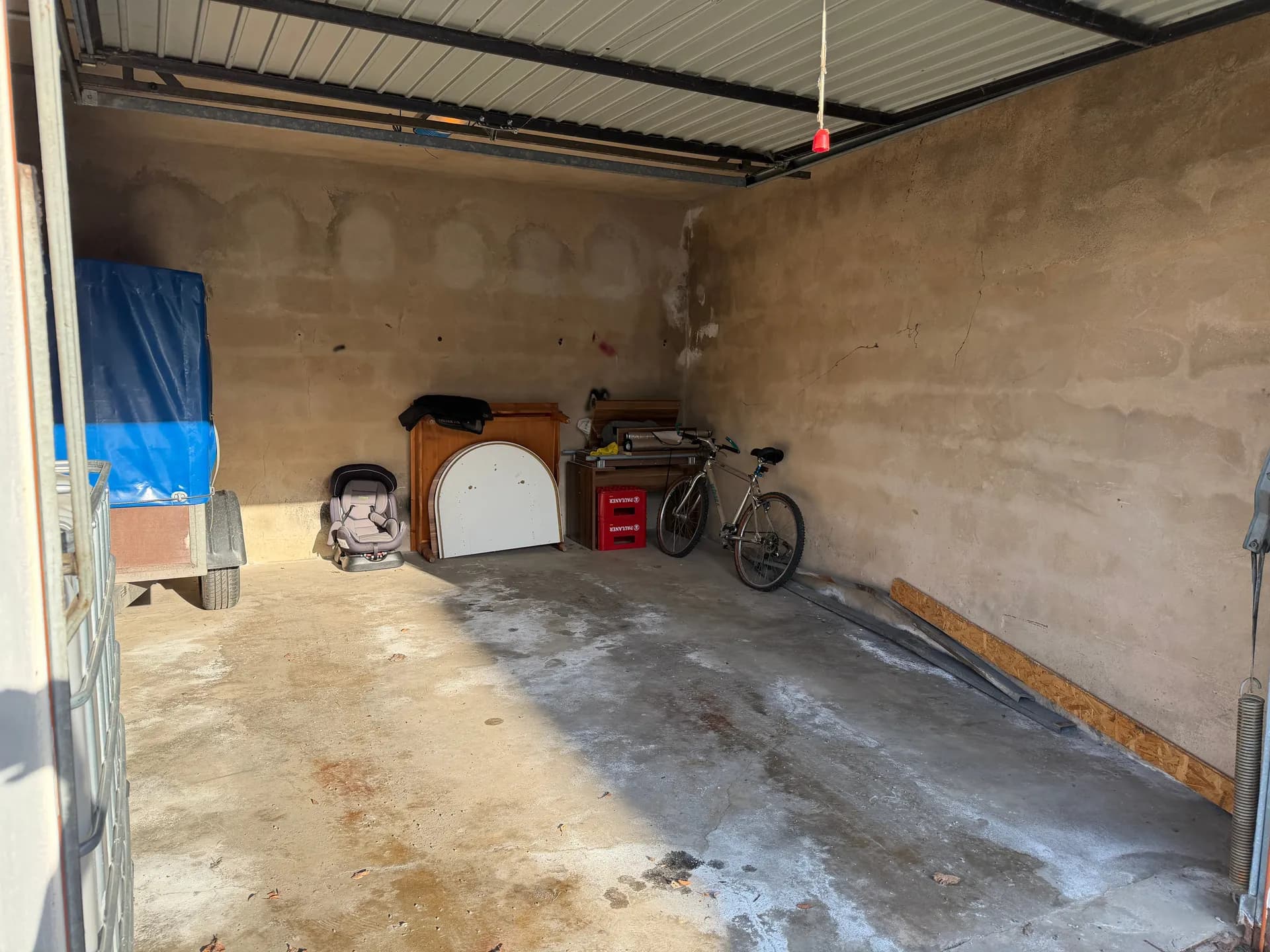 Großzügiger Innenbereich der Garage mit Betonboden, hoher Decke sowie reichlich Platz für Pkw, Fahrräder und Werkstattbereich.