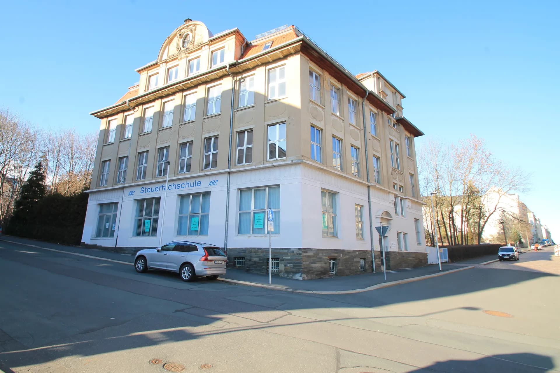 Repräsentatives historisches Eck- und Schulungsgebäude mit Mansarddach, Ziergiebel, großflächigen Fensterelementen und Natursteinsockel.