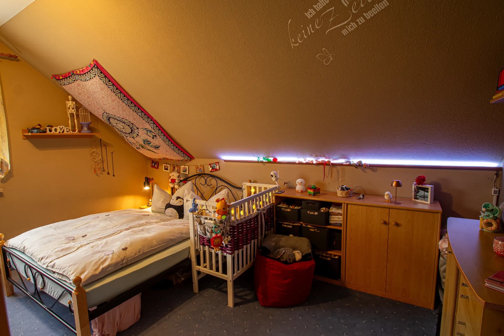 Gemütliches Schlafzimmer im Dachgeschoss mit Massivholzmöbeln, Doppelbett und großem Kleiderschrank.