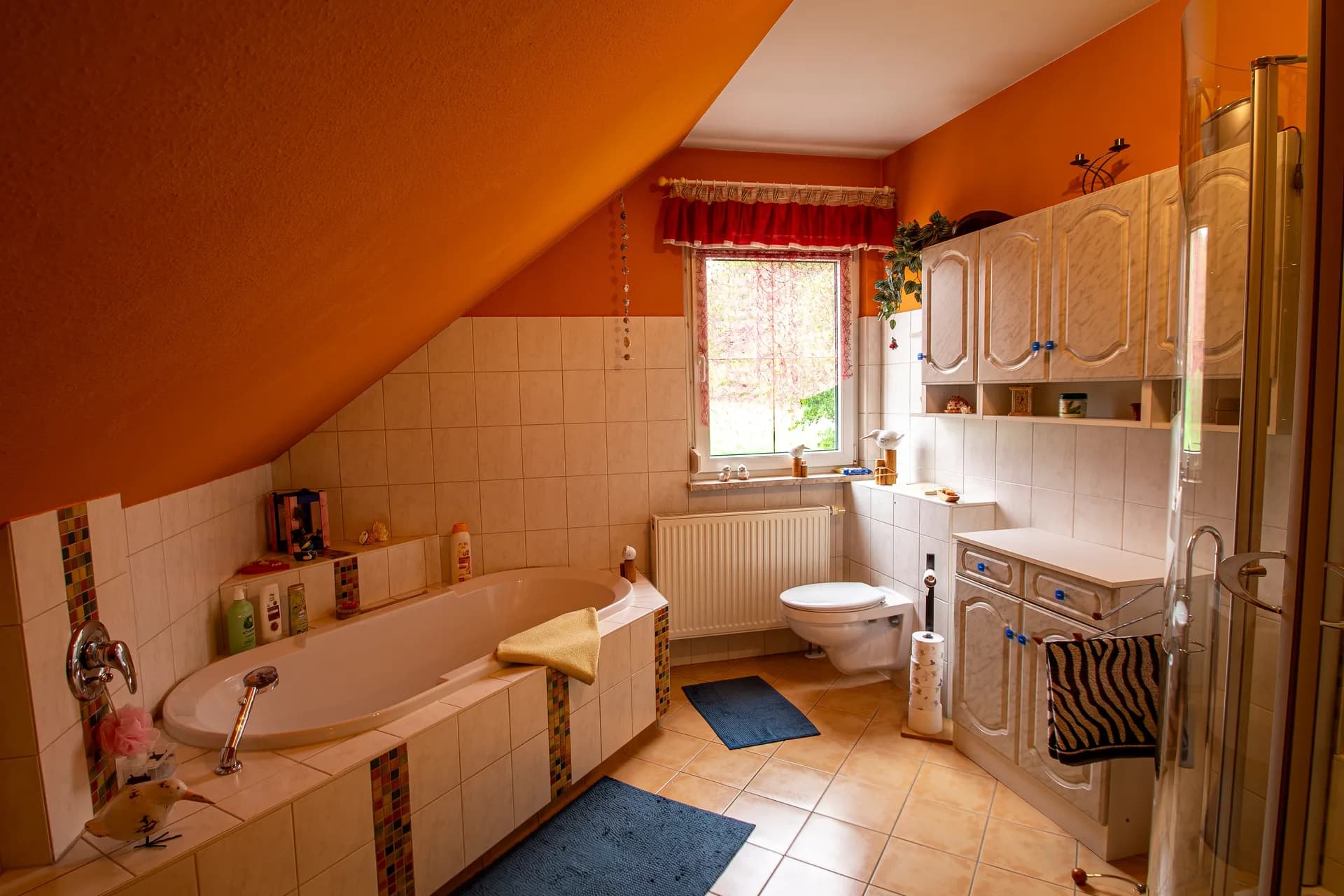 Großes Tageslichtbadezimmer im Dachgeschoss mit Einbauwanne, WC und praktischen Badmöbeln.